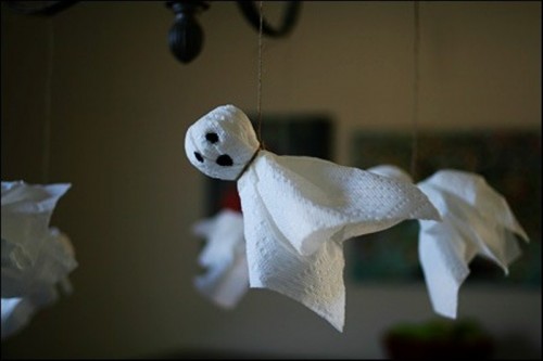 funny napkin ghosts hanging on a chandelier can be an easy craft for Halloween that even your kids can make