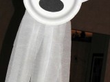 a funny ghost of a paper plate, cloth and some black paper is a fun and easy deocration for a kid’s Halloween party
