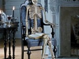 a skeleton in a vintage black chair is a stylish and refined idea of Halloween decor that is easy to make