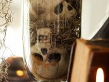 a glass with skeletons and hay is a simple and scary decoration to use for Halloween