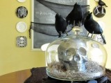 a cloche with a skull and hat plus blackbirds on top is a stylish Halloween decoration