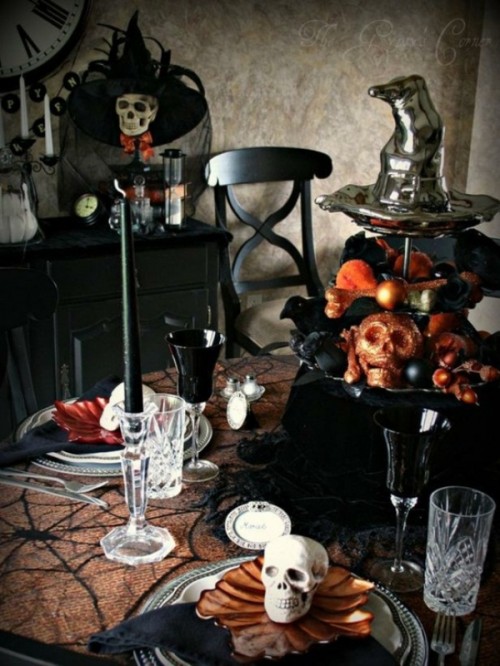 a black stand with skulls, blackbirds, ornaments and a witch hat on top is a stylish idea for Halloween