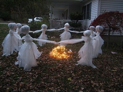 cheesecloth ghosts reeling around a fire are a scary and cool Halloween decoration for outdoors