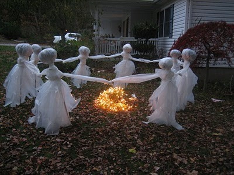 cheesecloth ghosts reeling around a fire are a scary and cool Halloween decoration for outdoors