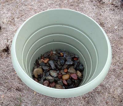 Pick a large enough but good looking planter or a bucket. Fill it with rocks and it'll be sturdy enough even for a large fir tree. (via themoderndiylife)