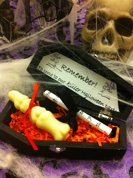 a black coffin filled with candies and sweets and with information is a cool party invitation