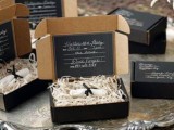 a refined black box with hay and an invite is a chic and cool idea for a modern Halloween party