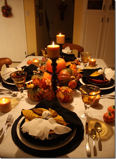 faux pumpkins and candles in tall candleholders will fit a stylish rustic Halloween tablescape
