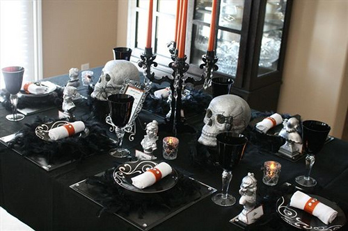a black candelabra with orange candles and elegant skulls is a stylish and refined Halloween centerpiece