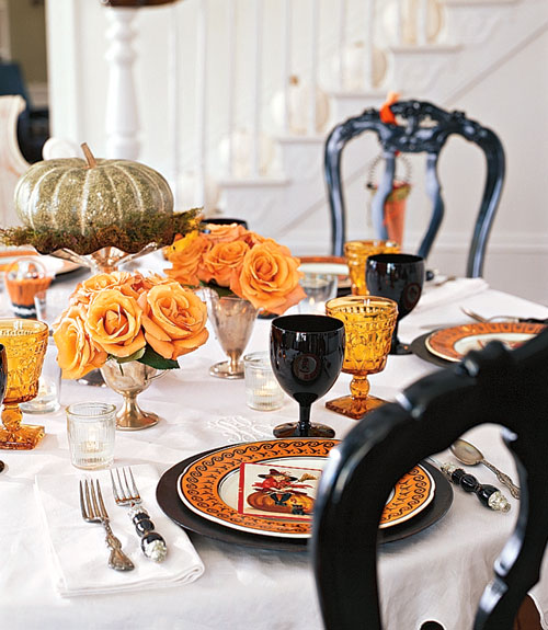 a gilded pumpkin on moss and a stand, orange roses in goblets are lovely for Halloween table styling