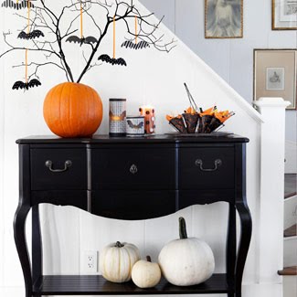 black branches inserted into a large pumpkin and decorated with black paper bats is a cool Halloween tree
