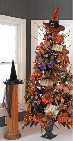 a black lit up Halloween tree decorated with leaves, glitter pumpkins, witches' hats and boots