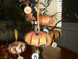 a black Halloween tree decorated with orange paper pumpkins on a stand is a bold and dramatic decoration