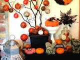 black branches in a black planter with orange and grey wrapped ornaments is a quirky and fun idea