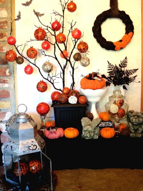 black branches in a black planter with orange and grey wrapped ornaments is a quirky and fun idea