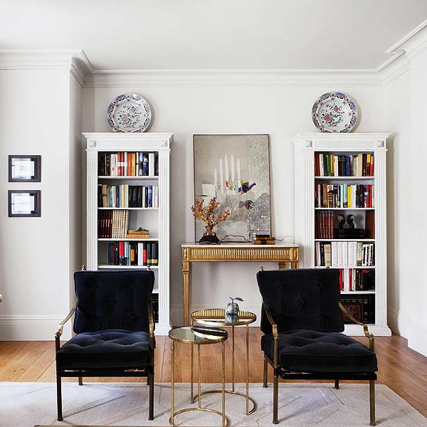 Two refined vintage bookcases painted white are nice to store books with style, and loungers finish off this space
