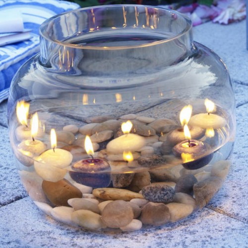 a large jar with pebbles and water plus floating candles is a cool centerpiece or relaxing decoration