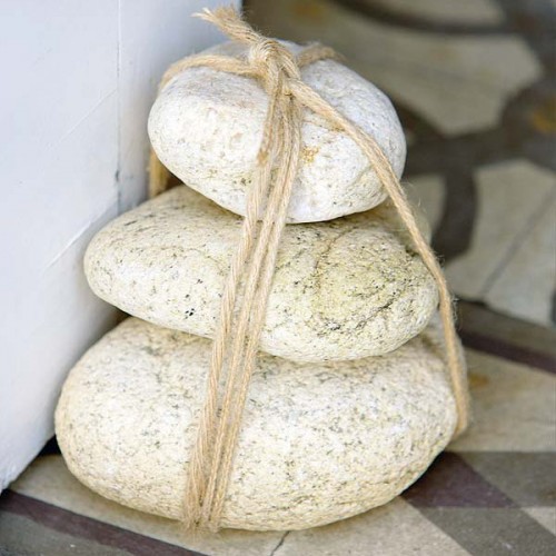 a doorstop made of a bunch of large pebbles with twine is a cool idea for a coastal home