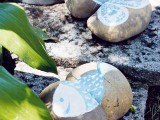 large pebbles with butterflies and fish painted on them are easy and cute garden decorations