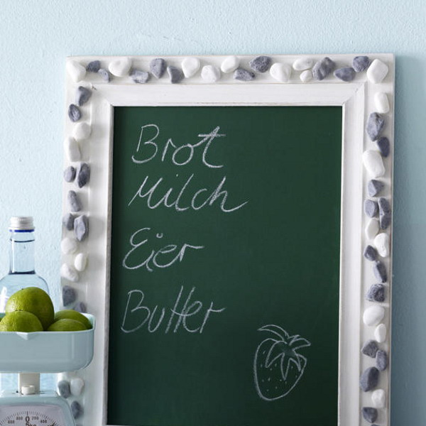 a chalkboard with a frame covered with pebbles is a cool beach or coastal home decor idea