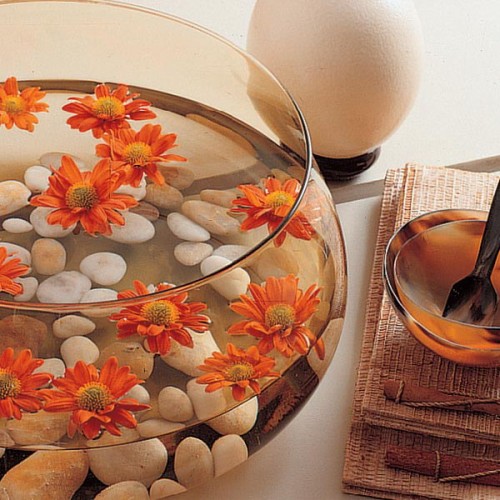 an aquarium with pebbles and bright blooms is a simple modern home decoration