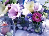 a glass box with pebbles and water plus bright blooms is a cool and bold centerpiece for any party