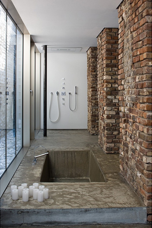 Bare brick works well with concrete in this shower design.