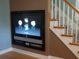 under the stairs space taken by a built-in TV is a great idea to use the awkward space in your home