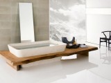 a minimalist bathroom with Japanese aesthetics, a wooden bench, a large mirror next to the tub and a statement artwork