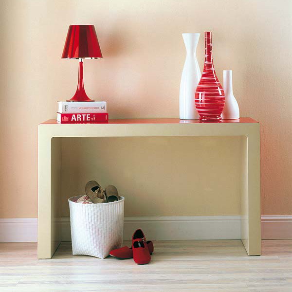 a narrow metallic console table and a white wicker cubby as a simple shoe storage in the entryway