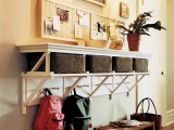 an open shelf and wicker cubbies for storage plus hooks make up a cool storage unit for a small entryway
