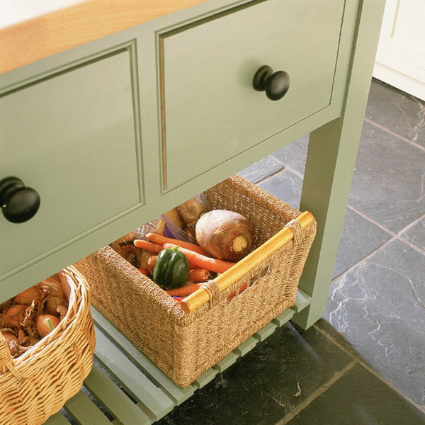 a green kitchen island with an open storage space, a couple of baskets for storing vegetables and fruits with a rustic touch