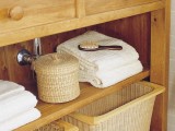 a large wooden bathroom vanity finished off with wicker cubbies to make storage more comfortable