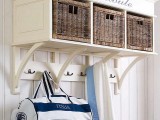 a white entryway storage unit with a shelf with inserted wicker cubbies for closed and hidden storage and some hooks for clothes