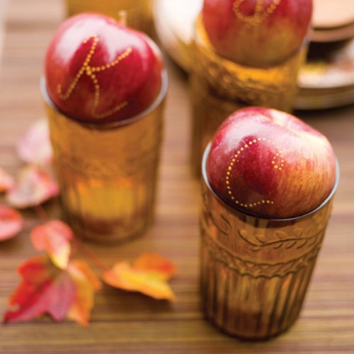 use letters on red apples placed on amber glasses as place cards that are yummy