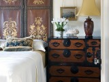 a painted and carved dark wooden screen and a matching colonial style sideboard to give a chic vintage feel to the space