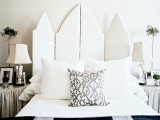 a chic white upholstered whimsily shaped screen is a cool headboard that will add a refined and chic touch to the space