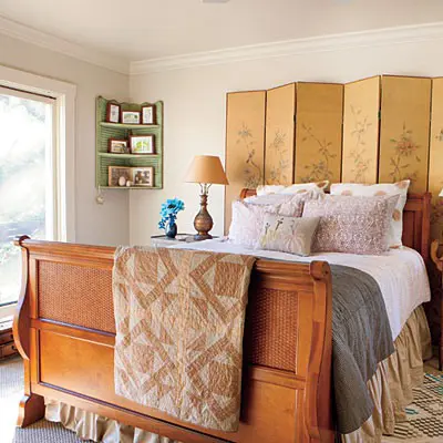 a marigold floral screen adds warmth and coziness to the bedroom and echoes with the rich stained bed