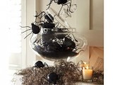 a scary Halloween decoration or centerpiece of hay, a glass jar with large spiders and candles is fantastic