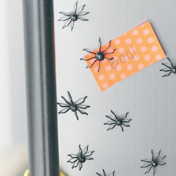 Decorate your fridge with mini spiders to make it look scary and Halloween like