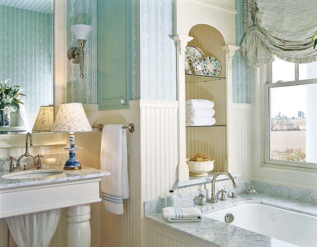 A vintage bathroom done in turquoise and neutrals, with a bathtub and niches with shelves, a large mirror and some curtains is very welcoming