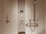 a neutral shower space clad with greige tiles of various scales and with a niche used fro storage is a smart solution