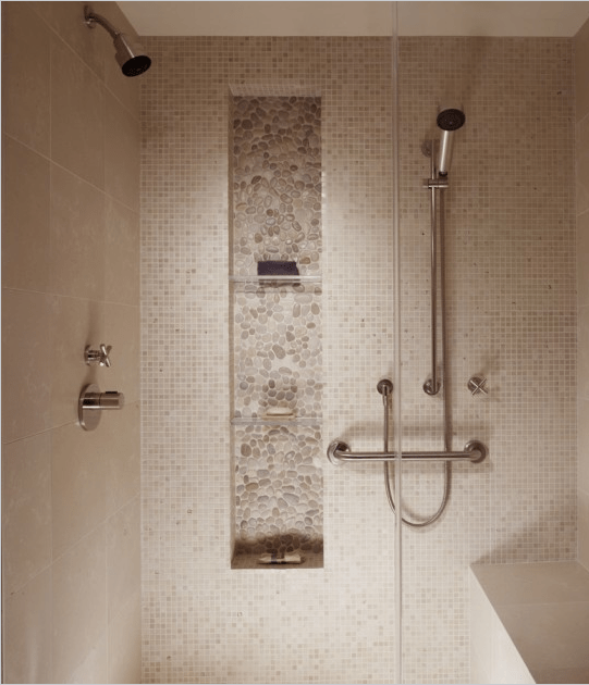 A neutral shower space clad with greige tiles of various scales and with a niche used fro storage is a smart solution