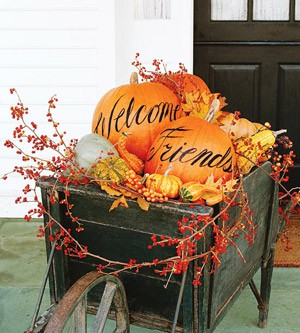 a cart with colorful pumpkins and letters, faux leaves and branches with berries will bring a rustic fall feel to the porch