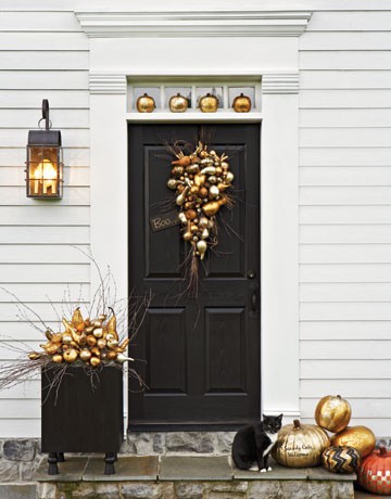 elegant Thanksgiving porch decor with metallic pumpkins and other veggies arranged, glitter and stenciled pumpkins on the steps is easy and bright