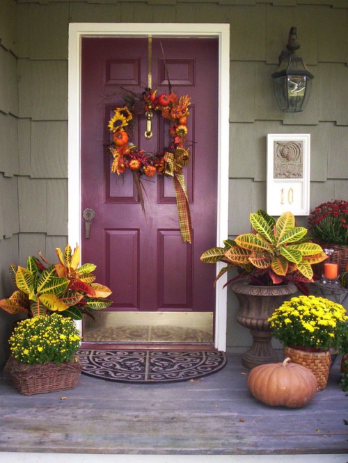 bright yellow flowers in baskets, pumpkins, candles and a cool faux pumpkin and bloom wreath