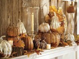 a vintage-inspired Thanksgiving mantel with wooden, mercury glass and plastic pumpkins, fall leaves and candles