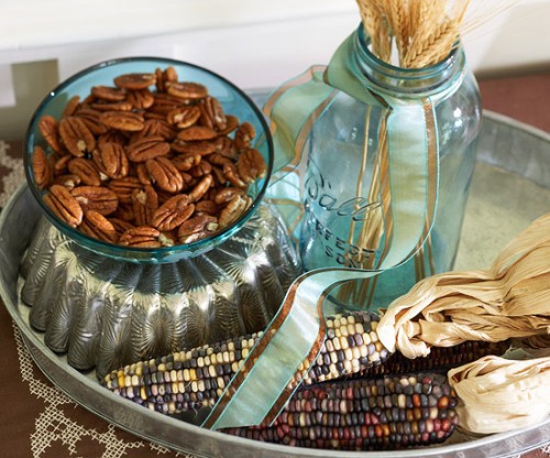 a fall or Thanksgiving centerpiece of wheat, corn cobs and pecans in a bowl is a stylish and all-natural idea