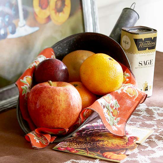 a metal shovel with apples, pears and prunes plus a bright napkin is a stylish fall or Thanksgiving centerpiece