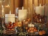 glass candleholders with candles and nuts around is a fast to make and easy fall and Thanksgiving centerpiece